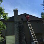 Stefan on a ladder working on a house