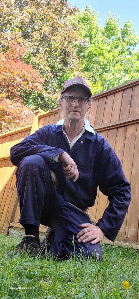 Customer posing in front of a fence on the grass in the backyard.